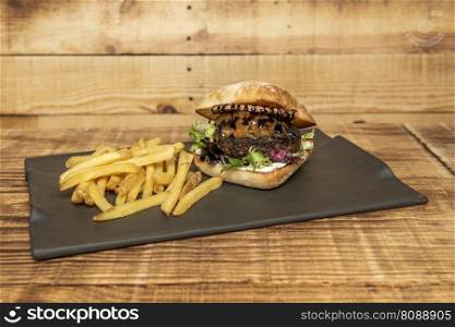 Duck meat burger with caramelized onion, lettuce, mayonnaise, goat cheese and barbecue sauce with side fries