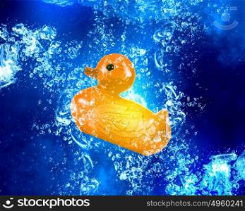Duck toy under water. Yellow rubber duck sinking in clear blue water