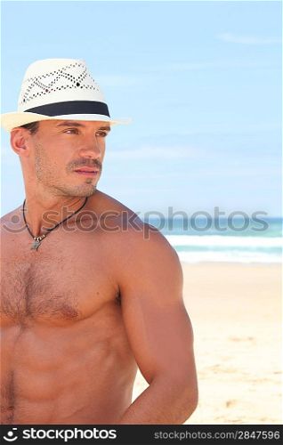 Dude posing in a straw hat on a sunny beach