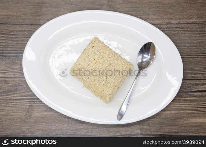 Dukan Diet. Fresh delicious diet cake at Dukan Diet on a porcelain plate with a spoon on a wooden background.. Dukan Diet. Fresh delicious diet cake at Dukan Diet on a porcelain plate with a spoon on a wooden background