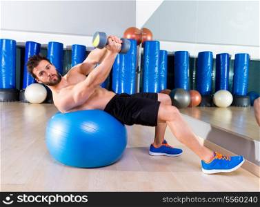Dumbbell bench press on fit ball man workout at fitness gym