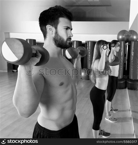 Dumbbell weightlifting man and women workout group at gym looking at mirror