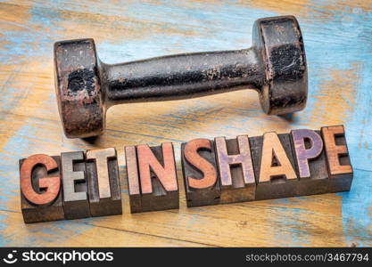 Dumbbell with get in shape text in vintage letterpress wood type - fitness concept