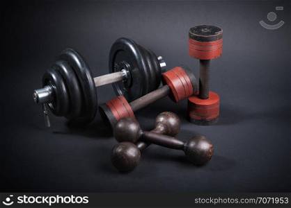 dumbbell with typesetting discs weighting on dark background