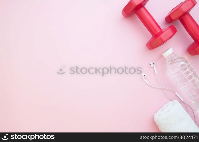 Dumbbells, bottle water on pink color background with copy space, Heathy lifestyle concept