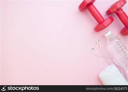 Dumbbells, bottle water on pink color background with copy space, Heathy lifestyle concept