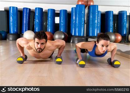 Dumbbells push-ups pushups couple at fitness gym workout