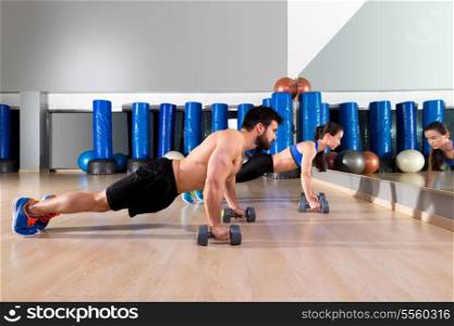 Dumbbells push-ups pushups couple at fitness gym workout