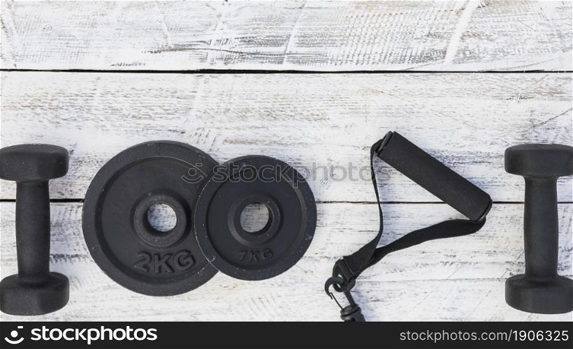 dumbbells weight plates fitness strap white wooden textured background. High resolution photo. dumbbells weight plates fitness strap white wooden textured background. High quality photo