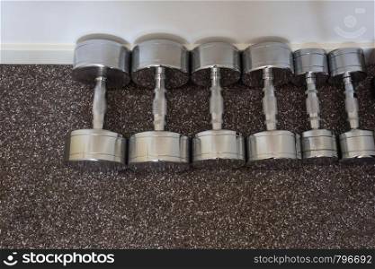Dumbells on the floor in fitness room, close-up. Dumbells on the floor in fitness room,