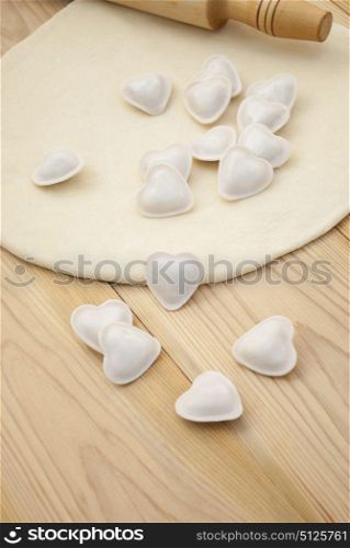 Dumplings in a heart shape dough and rolling pin.