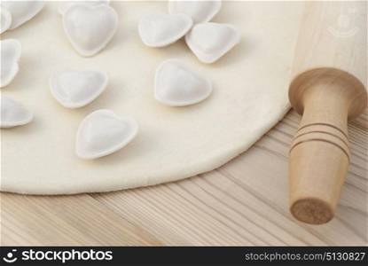 Dumplings in a heart shape dough and rolling pin.