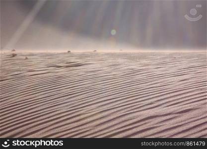 Dune of sand with sunbeams as closeup with copy space