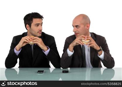 duo of businessmen eating hamburger