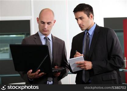 duo of young businessmen with laptop