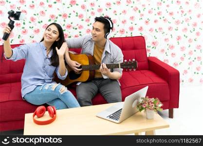Duo singer do vlog live singing song with guitar to share on social media. Using for vlog social media influencer concept.