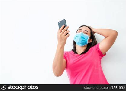 During the coronary epidemic, A woman wearing a mask communicate with friends using video calls with smartphones.
