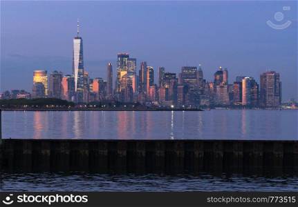 Dusk light reflects off the buildings onto Hudson Bay at sunset in Manhattan