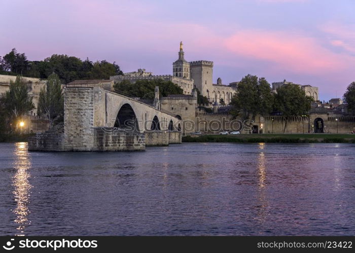 Dusk over the Pont d'Avignon (Pont Saint-Benezet) and the city of Avignon in the department of Vaucluse on the left bank of the Rhone River. it was the residence of the popes during their exile from Rome. Between 1309 and 1377, seven successive popes resided in Avignon and in 1348 Pope Clement VI bought the town from Joanna I of Naples. Papal control persisted until 1791 when, during the French Revolution, it became a part of France. The historic centre, which includes the Palais des Papes, the cathedral, and the Pont d'Avignon, became a UNESCO World Heritage Site in 1995.