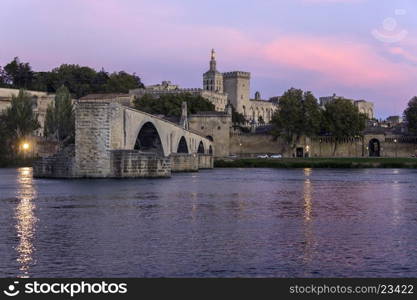 Dusk over the Pont d'Avignon (Pont Saint-Benezet) and the city of Avignon in the department of Vaucluse on the left bank of the Rhone River. it was the residence of the popes during their exile from Rome. Between 1309 and 1377, seven successive popes resided in Avignon and in 1348 Pope Clement VI bought the town from Joanna I of Naples. Papal control persisted until 1791 when, during the French Revolution, it became a part of France. The historic centre, which includes the Palais des Papes, the cathedral, and the Pont d'Avignon, became a UNESCO World Heritage Site in 1995.