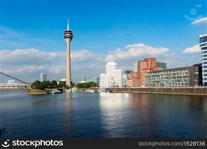 Dusseldorf&rsquo;s Media Harbor (Medienhafen) with Rheinturm tower and modern architecture by Frank O. Gehry.