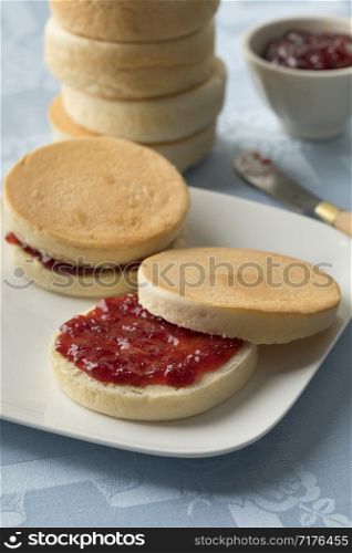 Dutch beschuitbollen, crispy baked roll, with red strawberry jam for breakfast