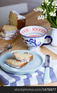 dutch cake and cup of tea and a bouquet of lilies of the valley on the table