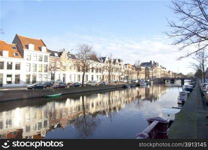 Dutch canal with old houses and boats with blue sky