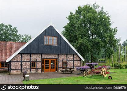 Dutch countryside with renovated farmhouse used as museum and field with old agricultural machinery. Dutch countryside with farmhouse and field with old agricultural machinery