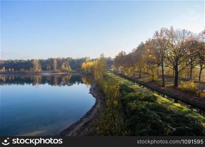Dutch landscape with calm river and blue sky, autumn season colorful yellow and orange trees, top view in the Netherlands beauty. Dutch landscape with calm river and blue sky, autumn season colorful yellow and orange trees, top view in the Netherlands