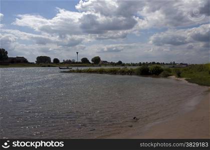 dutch river in the wide landscape with boats