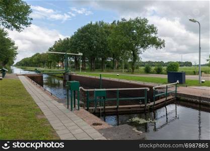 Dutch rural landscape with canal and old sluice in Friesland. Dutch rural landscape with canal and old sluice