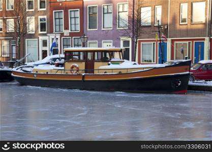 Dutch tugboat in a frozen canal in winter