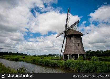 Dutch windmill with a cloudy sky in the summer