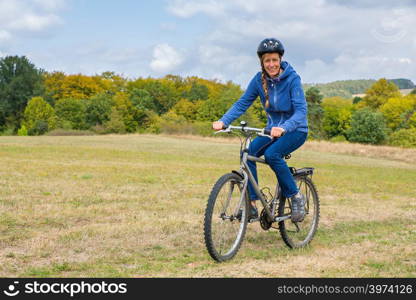 Dutch woman cycling on mountain bike in dutch natural landscape