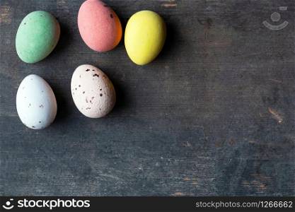 Dyed colorful easter eggs on a vintage wooden background texture, soft pastels modern design space for text. Dyed colorful easter eggs on a vintage wooden background texture, soft pastels modern design