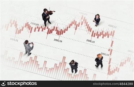 Dynamics of growth in business. Top view of business people and graphs and diagrams on floor