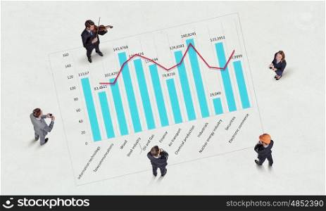 Dynamics of growth in business. Top view of business people and graphs and diagrams on floor