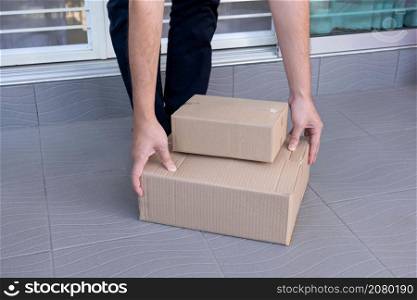 E-commerce concept a man leaving home and lifting the boxes for sending them to his customers via tracking express.