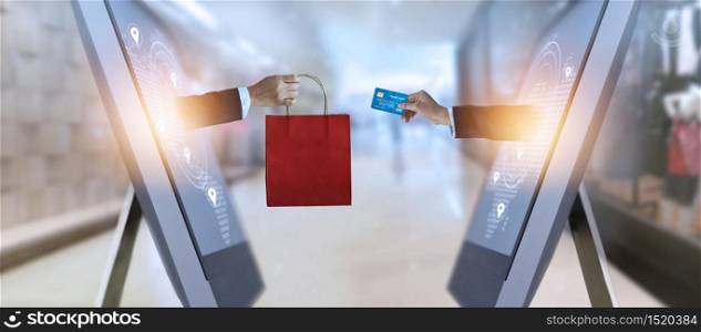 e-commerce, hand holding shopping bag and credit card from screen and global network, shopping and payments online concept, all on credit card are design up