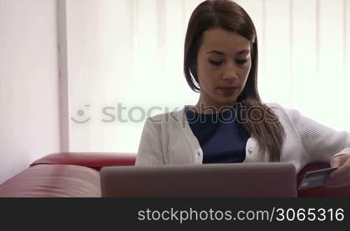 E-commerce with happy woman using pc and credit card while shopping on the web at home