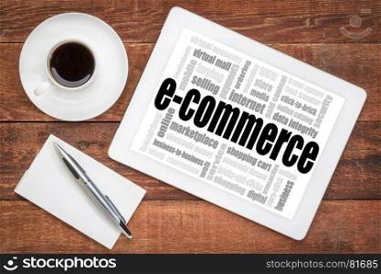 e-commerce word cloud - a digital tablet on a rustic wooden table with a cup of coffee