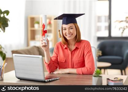 e-learning, education and people concept - happy smiling female graduate student in mortarboard with laptop computer and diploma at home. student woman with laptop and diploma at home