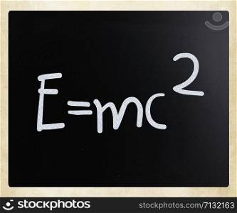 E=mc2 handwritten with white chalk on a blackboard