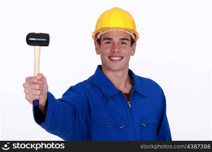 Eager young worker holding rubber mallet