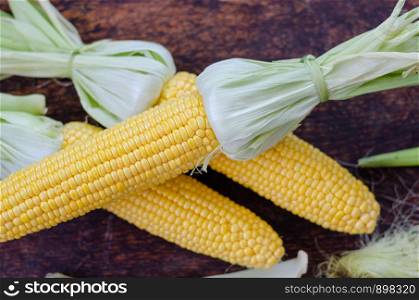 Ear of maize or corn on the dark wooden background.