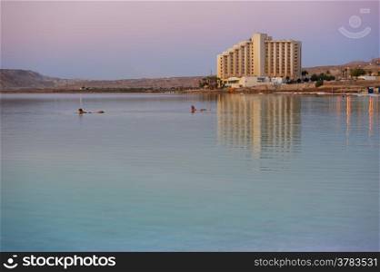 Early morning at the Dead Sea - the mountains, buildings and their reflection in the water