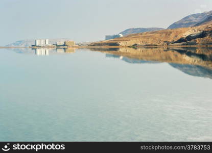 Early morning at the Dead Sea - the mountains, buildings and their reflection in the water