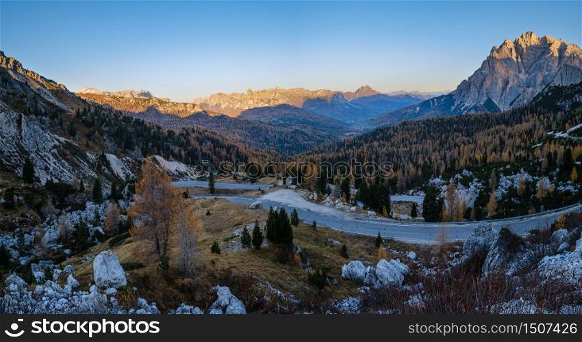 Early morning autumn alpine Dolomites mountain in first sunrays. Peaceful panoramic view from Valparola Pass, Belluno, Italy. Picturesque traveling, seasonal, and nature beauty concept scene.