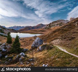 Early morning autumn alpine Dolomites mountain scene. Peaceful Valparola Pass and Lake view, Belluno, Italy.   Picturesque traveling, seasonal, and nature beauty concept scene.